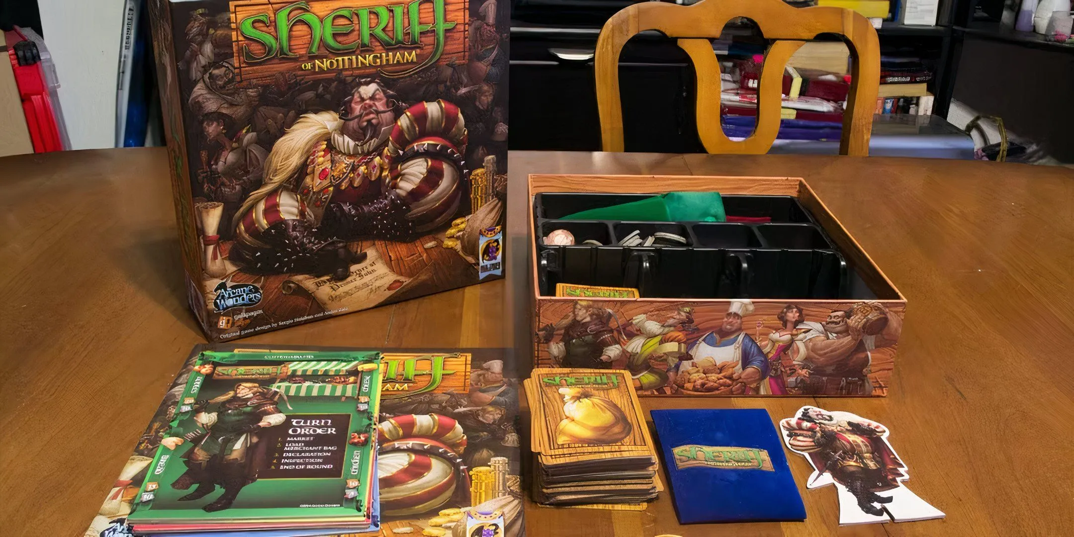 Các thẻ bài và bảng game Sheriff of Nottingham được bày ra, gợi liên tưởng đến tình huống tranh giành quyền hướng dẫn luật.
