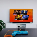 Hệ thống súng light gun G’aim’e Plug & Play đặt trước màn hình TV, sẵn sàng cho trải nghiệm game Time Crisis chân thực.