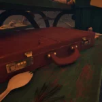 Rương bí mật Briefcase màu vàng xám nằm trên băng ghế gỗ mục ở khu vực Bàn Picnic trong Grounded 2